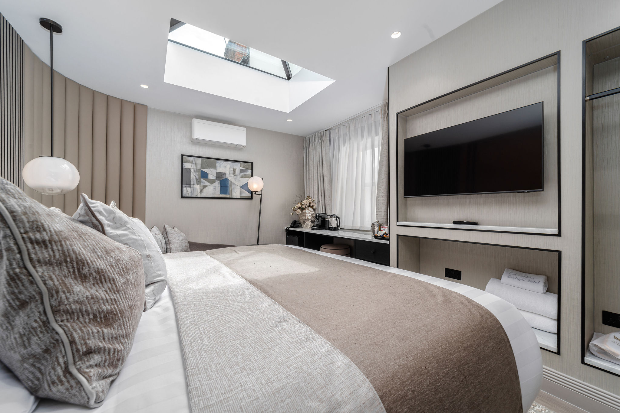 A calm, neutral bedroom at No.4 Carlton with a skylight