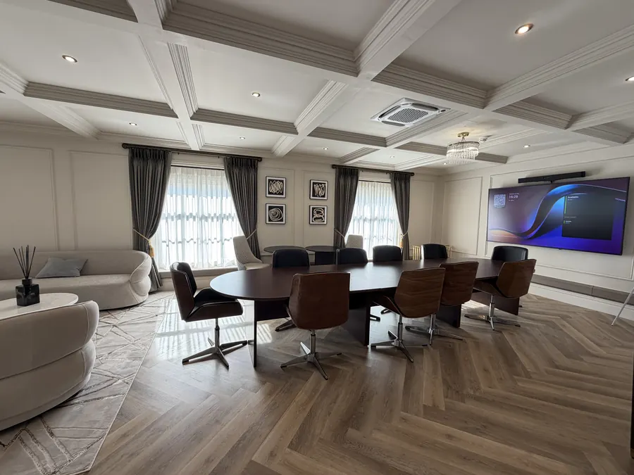 The Atelier boardroom with a long table and screen