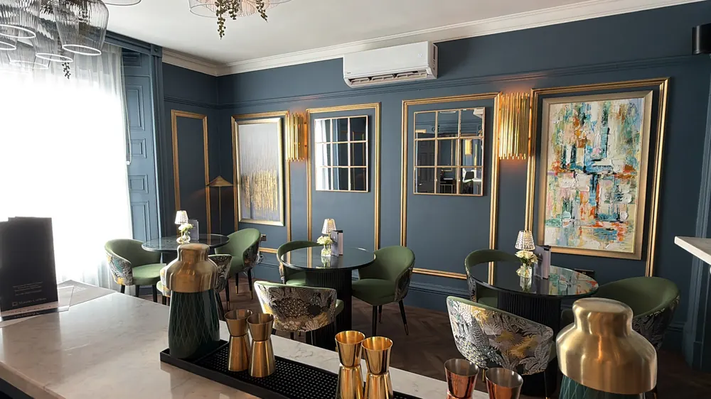 The lounge in Nocturne with green velvet chairs