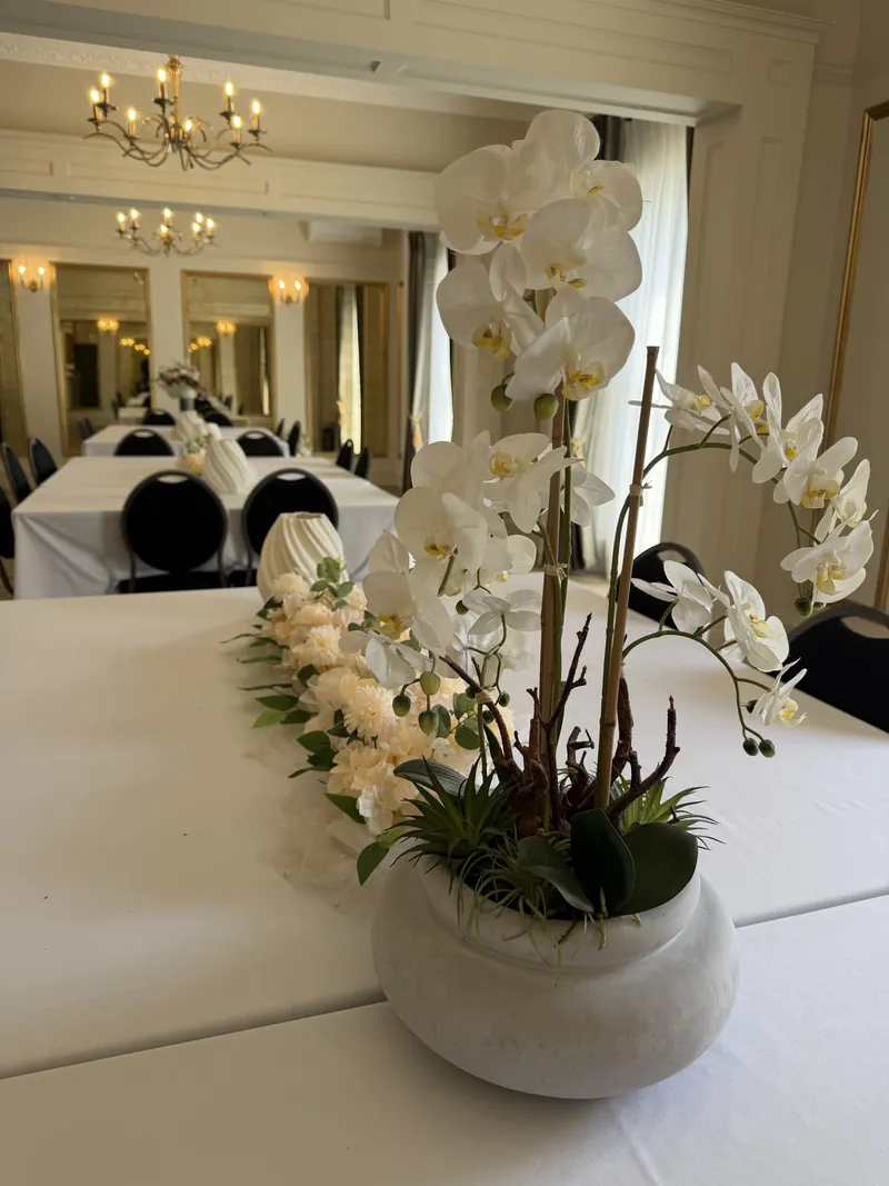 One long table beneath the chandelier in Orchidée
