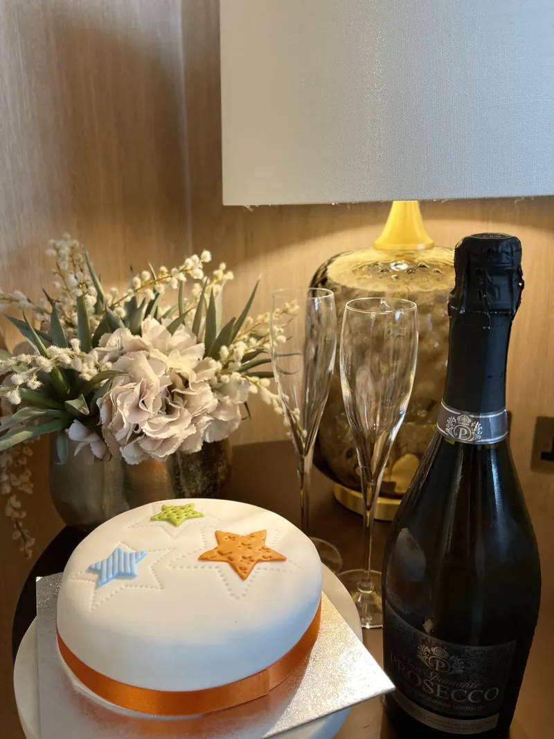 A celebration cake with a bottle of champagne