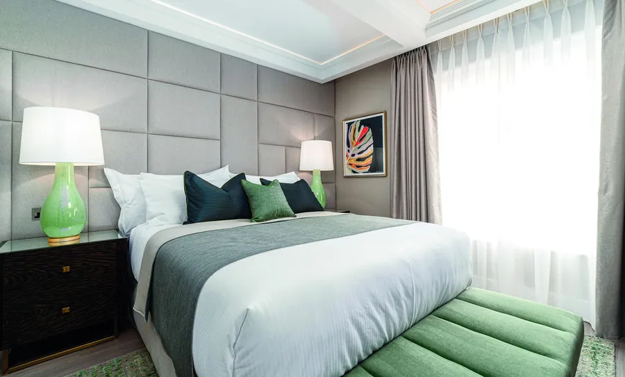 A bedroom at No.4 Carlton with panelled walls and a chocolate throw