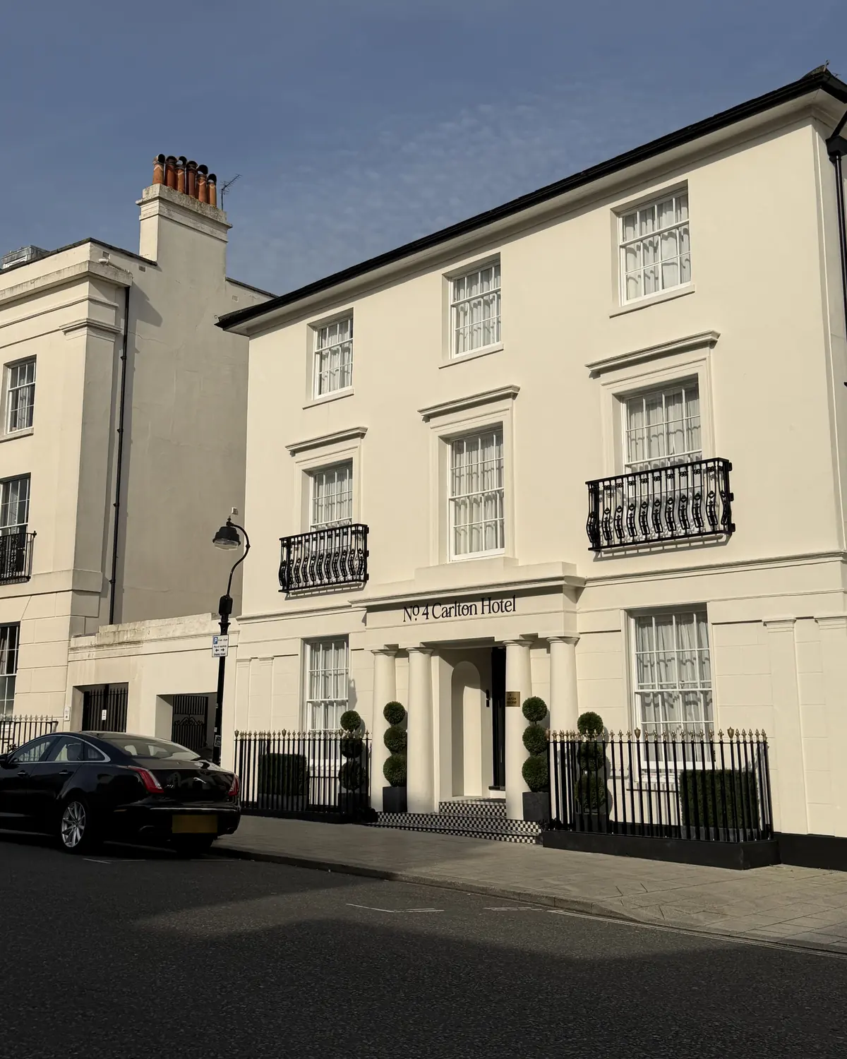The white Georgian façade of No.4 Carlton on Carlton Crescent at golden hour, with its four Doric columns